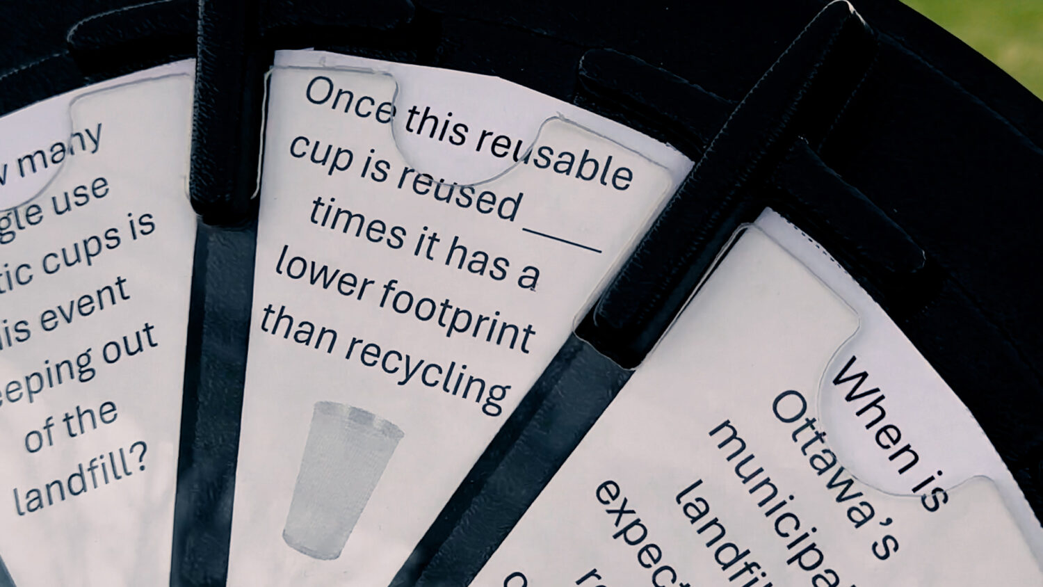 An educational prop reads "Once this reusable cup is reused BLANK times it has a lower footprint than recycling". Photo by Craig Conoley/EnviroCentre.