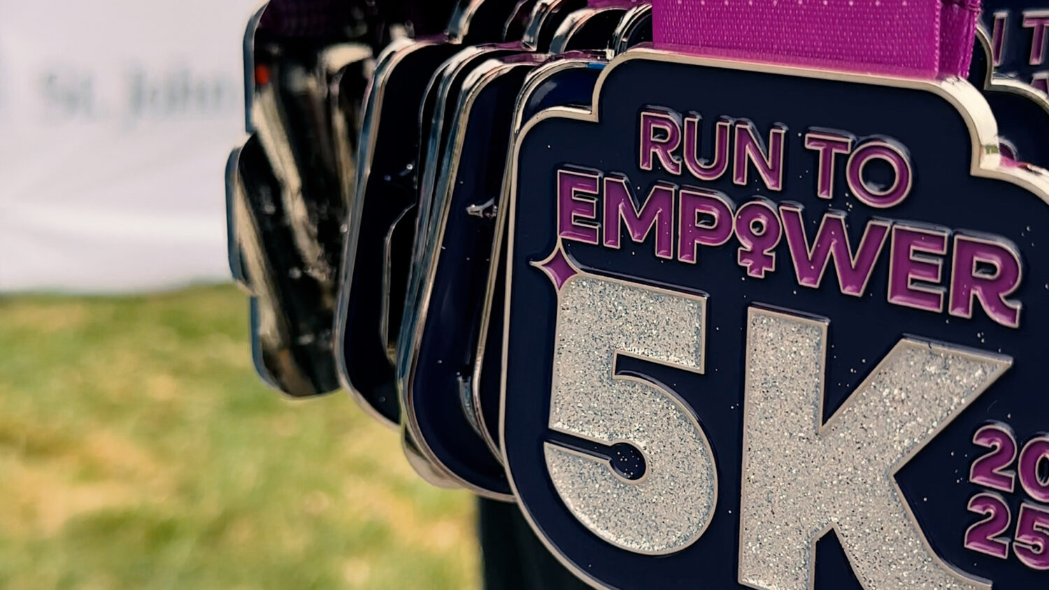 A stack of purple medals reading "Run to Empower 5K". Photo by Craig Conoley/EnviroCentre.