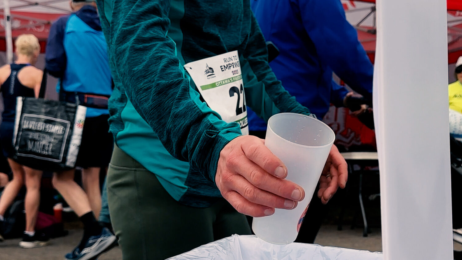 A runner drops a reusable cups into a bin. Photo by Craig Conoley/EnviroCentre.