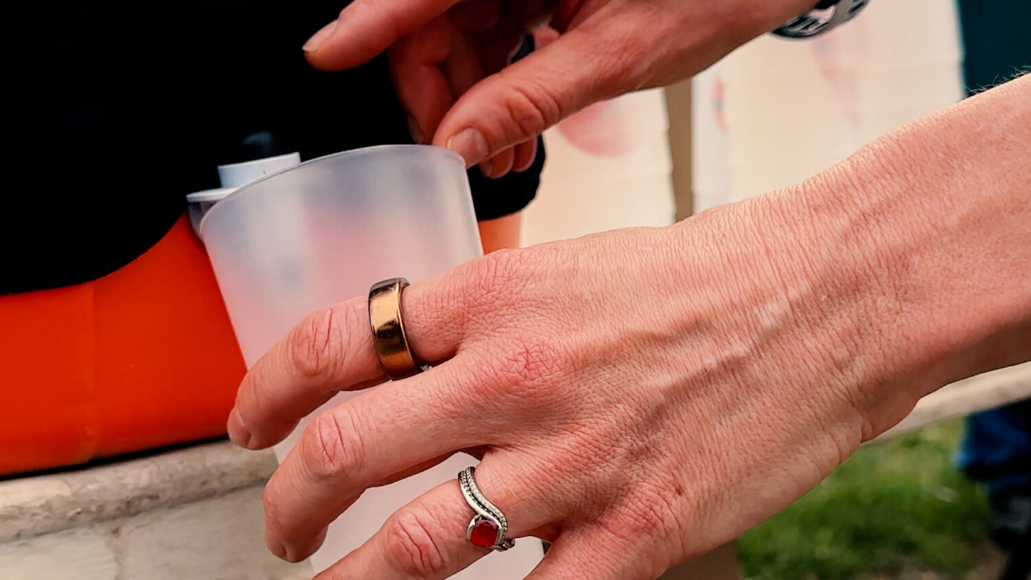 A race volunteer fills a reusable cup from an insulated container. Photo by Craig Conoley/EnviroCentre.