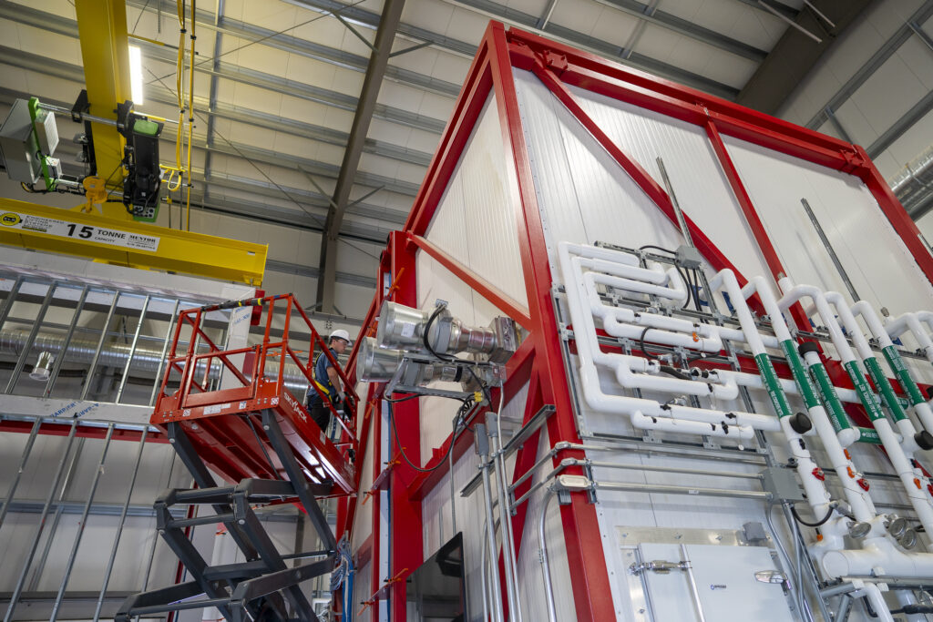 CABER program staff work in a lift adjusting the exterior of CanmetENERGY test housing equipment.